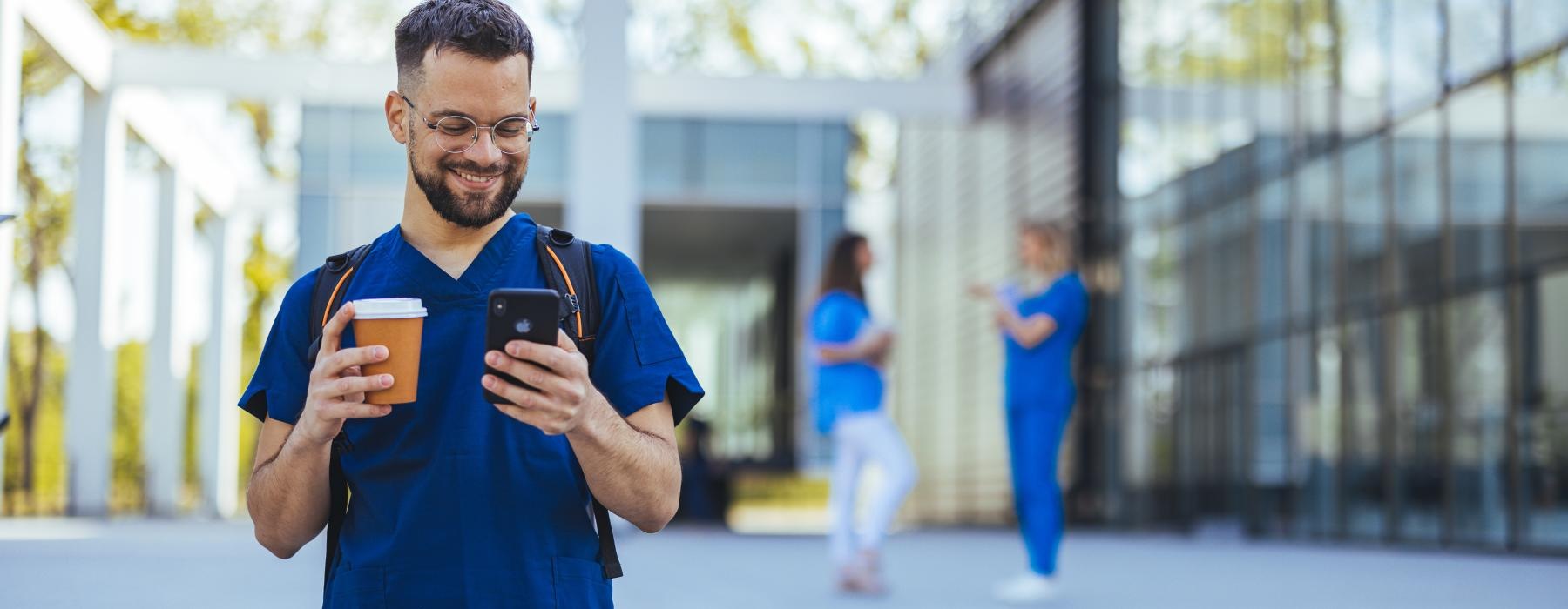 a man holding a cup and a cell phone